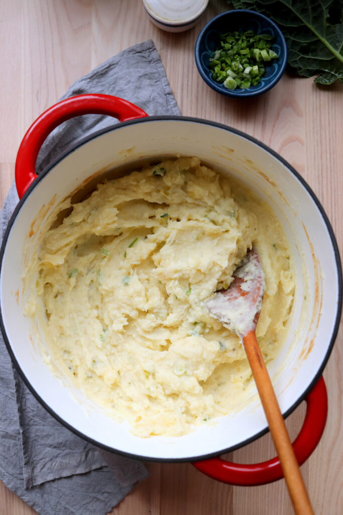fluffy mashed potatoes served from a Dutch oven with crisp edges