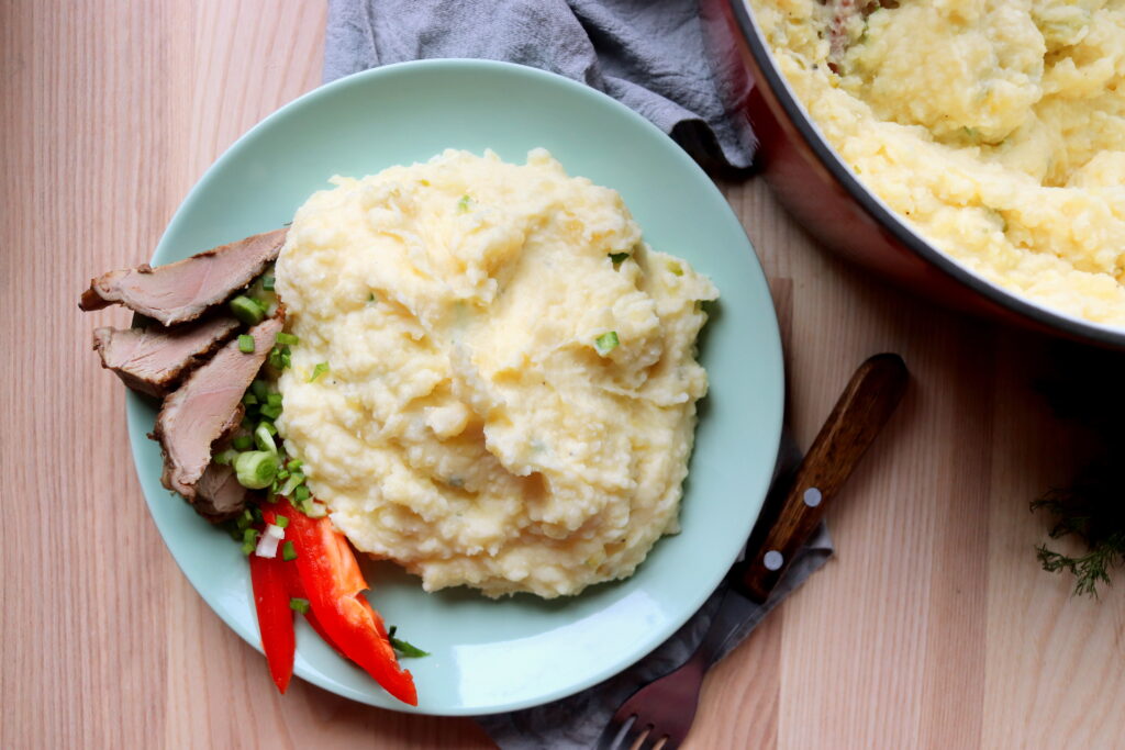 Golden topped mashed potatoes baked in a Dutch oven made with rich cream cheese