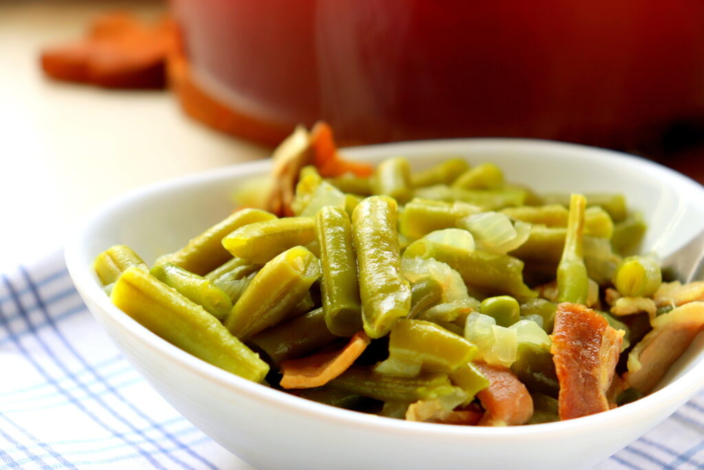 Close up of green beans cooked with smoky bacon