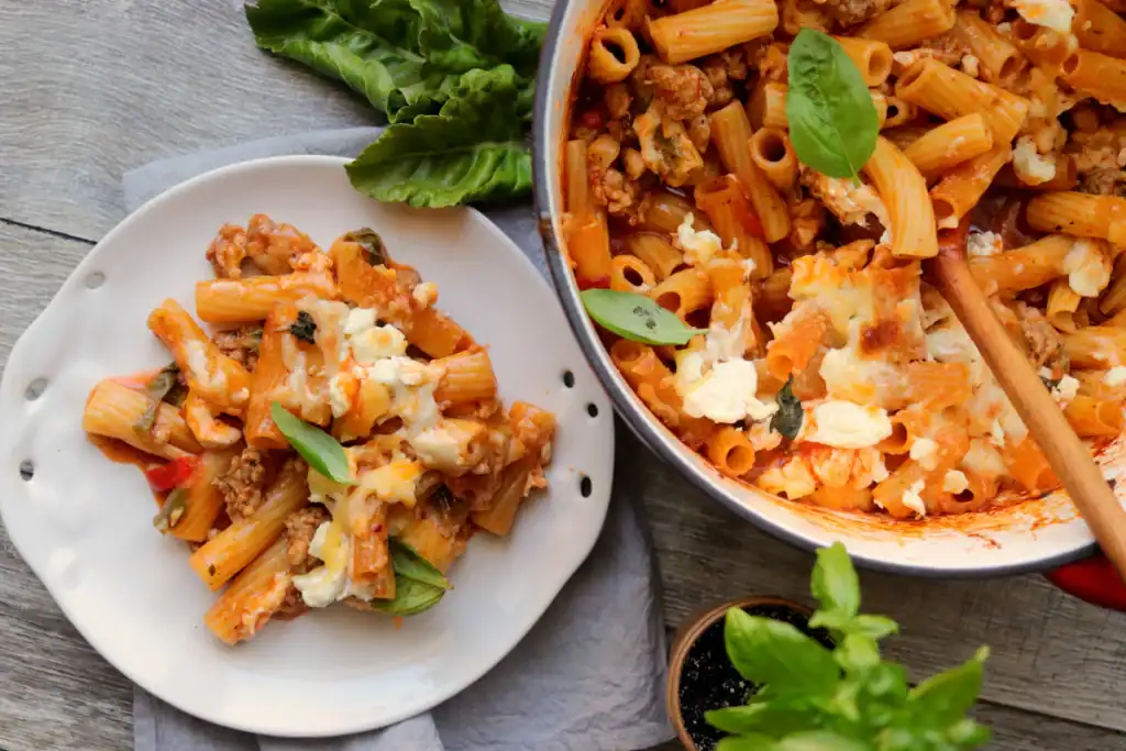 Dutch oven ziti bake with golden cheese topping and hearty tomato sauce.