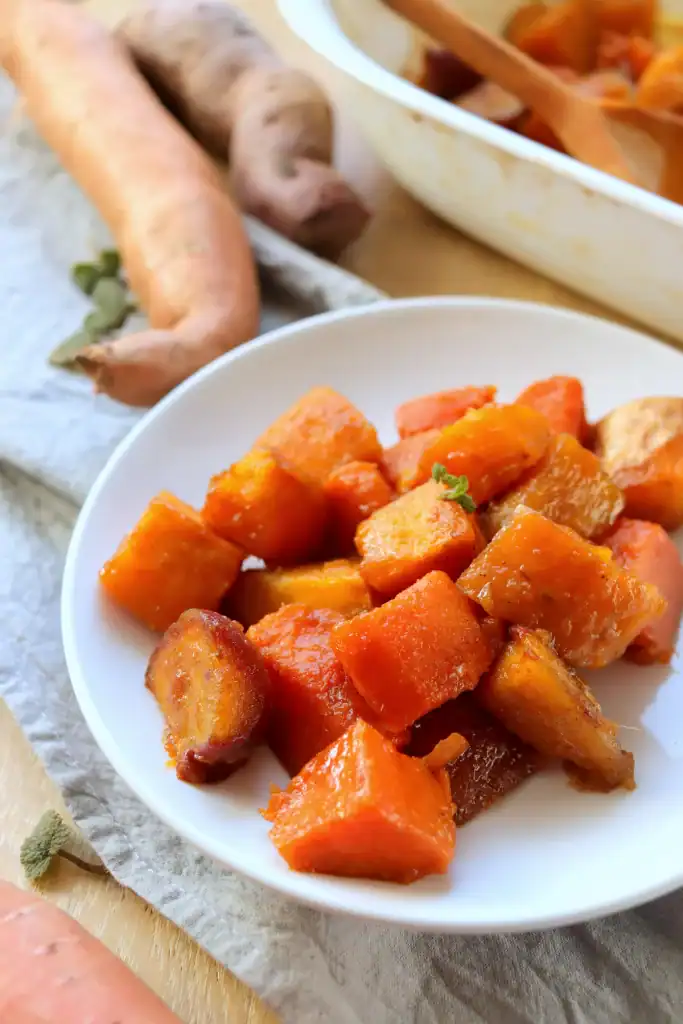 Sliced sweet potatoes in a Dutch oven with a glossy caramelized glaze.