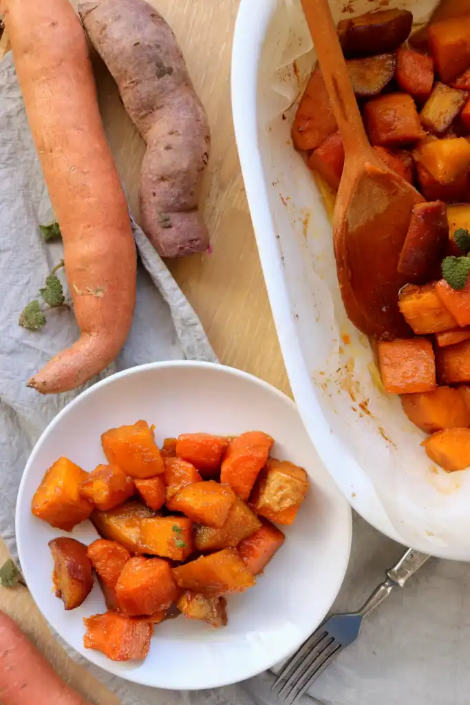 Dutch oven filled with glazed sweet potatoes coated in brown sugar and butter.