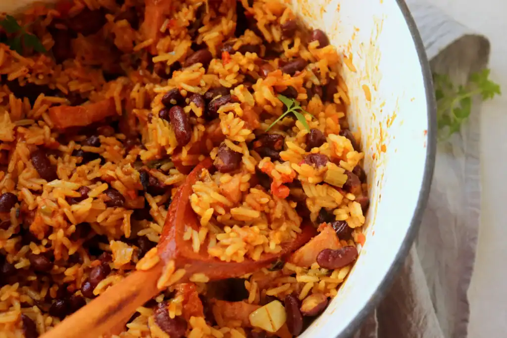 One pot red beans and rice in a Dutch oven with fluffy white rice and spicy sausage.