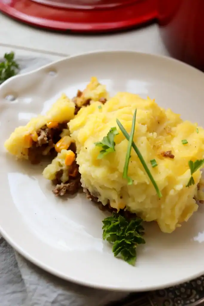 Classic shepherd’s pie in a Dutch oven with browned, fluffy potato topping.

