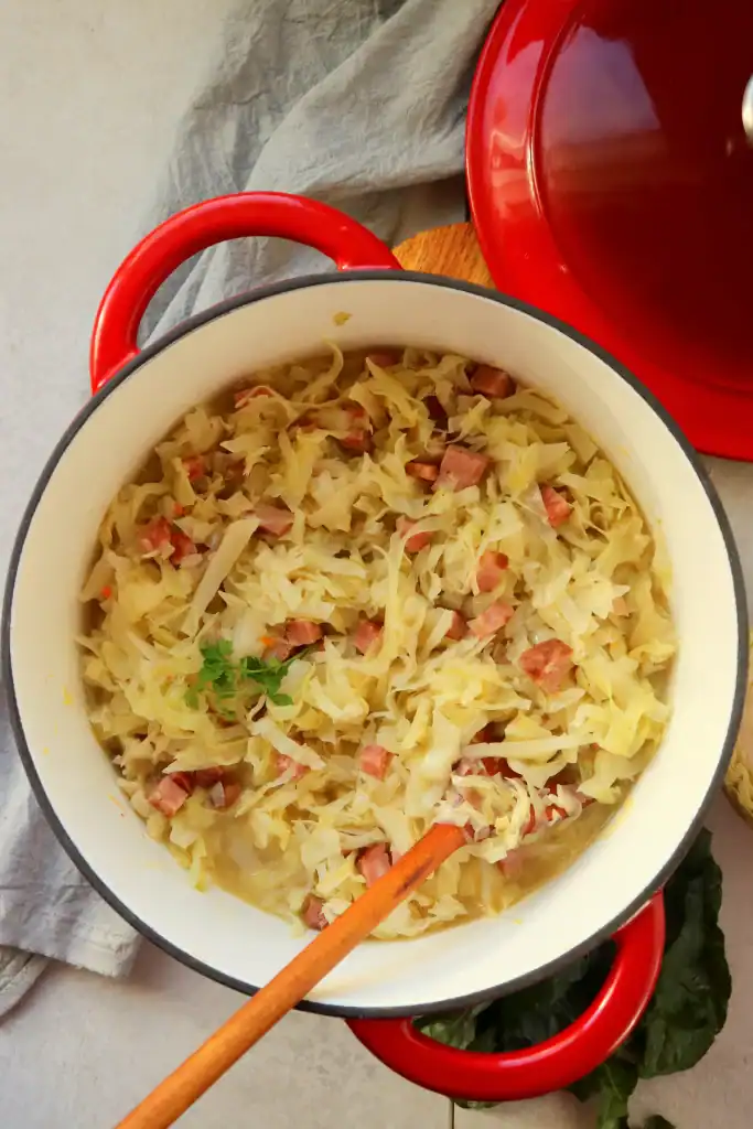 Dutch oven filled with tender Southern-style cabbage and andouille sausage